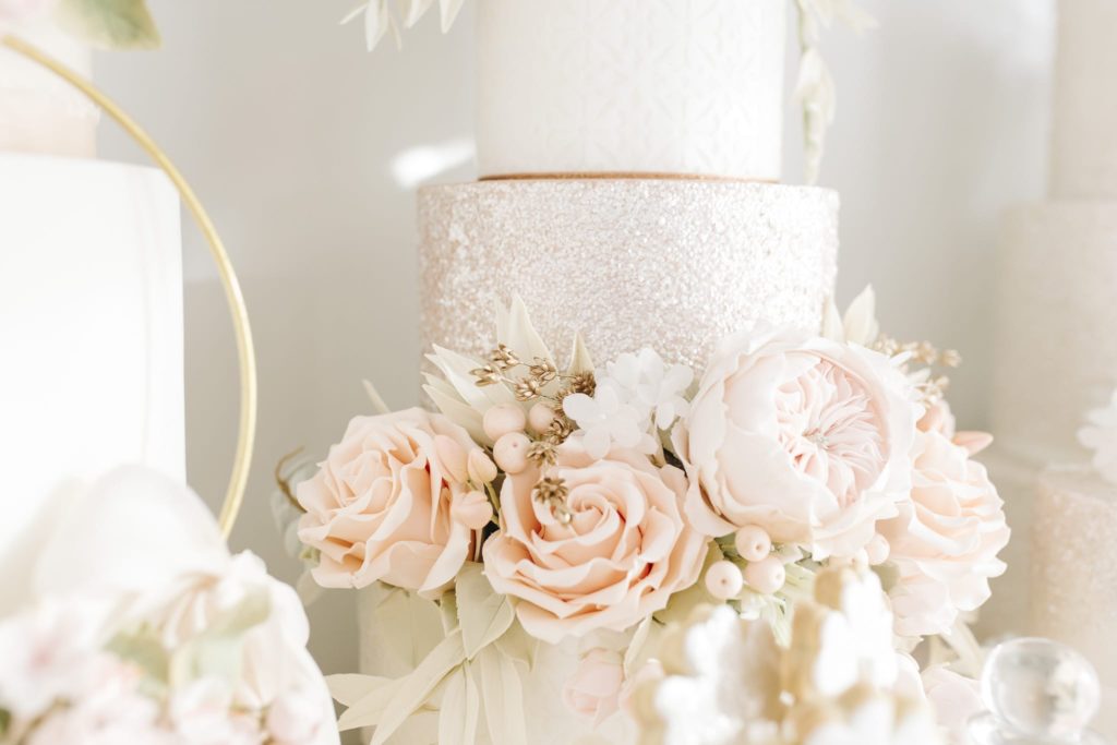 Luxury wedding cake from Hayley Elizabeth Cake Design, sugar flower peonies, foliage, sugar roses and rose gold shimmer. Fondant icing, textured wedding cake, dessert table, wedding cake inspiration